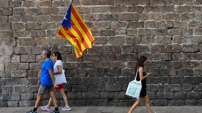 Dos manifestantes a favor de la independencia de Cataluña con una bandera "estelada", durante la Diada, el 11 de septiembre de 2022.