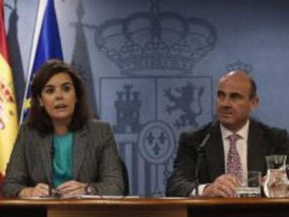 La vicepresidenta del Gobierno, Soraya S&aacute;ez de Santamar&iacute;a, y el ministro de Econom&iacute;a, Luis de Guindos, durante la rueda de prensa posterior al Consejo de ministros