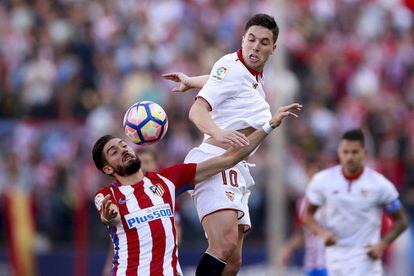 Yannick Carrasco del Atletico de Madrid lucha por el balón con Samir Nasri del Sevilla.