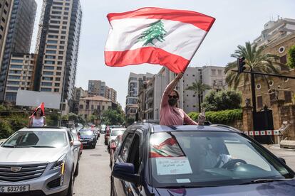 Una manifestante ondea la bandera libanesa durante un convoy de protesta durante la sesión parlamentaria este martes en Beirut