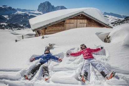 Niños jugando en la nieve en la estación de Dolomiti Superski, en Italia.