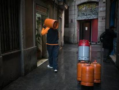Un repartidor de bombonas de butano hace el reparto por las calles de la ciudad de Barcelona.  