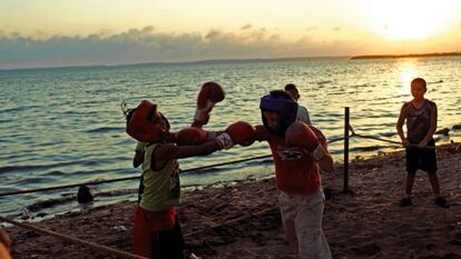 Durante el ocaso en una playa de Cienfuegos, un grupo de muchachos se ejercita en el boxeo.