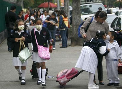Algunos estudiantes se protegen con mascarillas de la infección de la gripe A para asistir a clase.