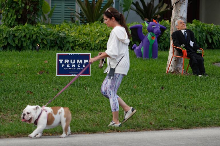 Una mujer pasea a su perro en una calle de Miami este sábado 31 de octubre.