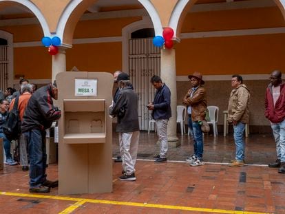 Ciudadanos esperan en fila para emitir su voto en el Colegio Mayor de San Bartolomé, en Bogotá, este domingo.