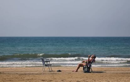 Una dona pren el sol a la platja de Salou.