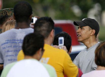 El presidente electo, Barack Obama, conversa con varios <i>marines</i> después de ejercitarse en el gimnasio de su base, ayer en Hawai.