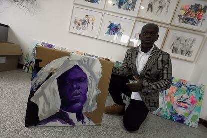 El artista Eduardo Malé, de Santo Tomé y Príncipe, posa con uno de sus cuadros en su estudio de Ponferrada (León).