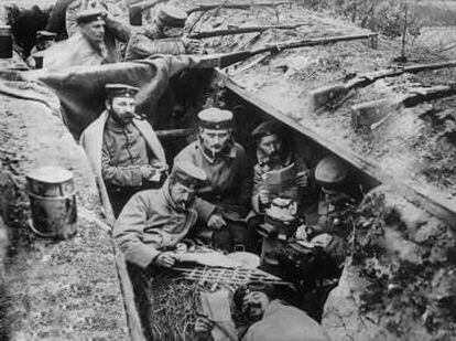 Soldados leen en una trinchera de la Primera Guerra Mundial.