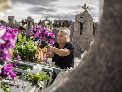 Esmeralda, de la familia Maya de la Rosa, preparando la decoracion floral en la tumba de sus familiares en el cementerio de La Almudena de Madrid