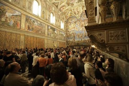 Una multitud de turistas contempla los frescos de la Capilla Sixtina del Vaticano. 