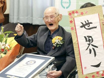 Watanabe, al recibir la distinción de Guinness a su récord, junto a una caligrafía suya en japonés.