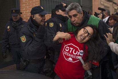 La policía retira a varios activistas de la entrada del domicilio, en el número 10 de la calle Sierra de Palomeras, en el barrio vallecano de Entrevías. La mujer cuenta con una pensión mensual de 630 euros.