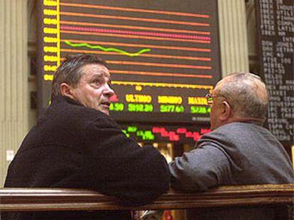 Dos <i>brokers</i> contemplan con preocupación las cotizaciones en la Bolsa de Madrid.