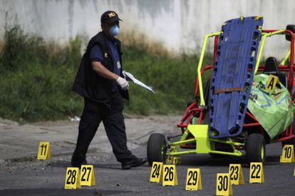 Un polic&iacute;a examina la escena de un tiroteo en una pista de karts en el que murieron dos hombres el 7 de octubre. 