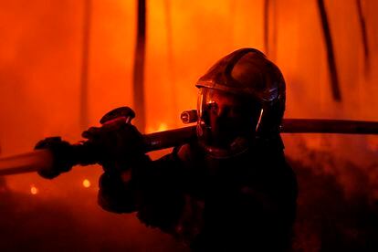 Un bombero sostenía una manguera el miércoles para luchar contra el fuego cerca de Hostens, al sur de Burdeos, en una foto proporcionada por el cuerpo de bomberos del departamento de Gironda.
