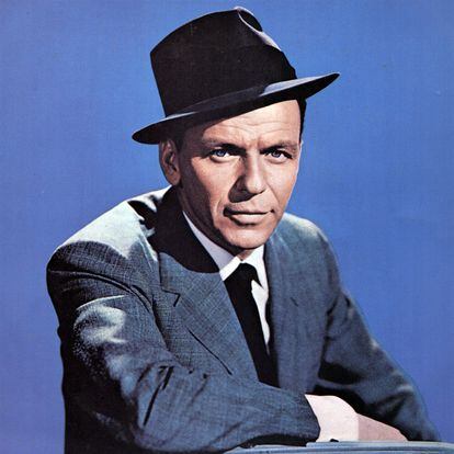 Frank Sinatra, posando con su atuendo característico de traje y sombrero.