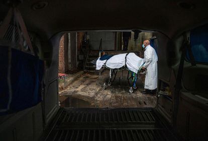 Un trabajador de una funeraria traslada el cadáver de una víctima de coronavirus en Baltimore, Maryland (EE UU). Estados Unidos llegó este jueves a 18.634.141 casos confirmados y a 328.849 fallecidos por la covid-19, de acuerdo con el recuento independiente de la Universidad Johns Hopkins.