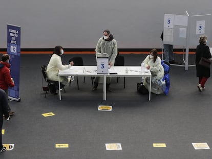 Votantes aguardan este domingo ante la mesa de un colegio electoral en Lisboa para depositar su papeleta.