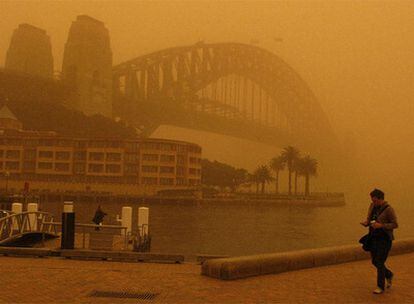 Un hombre pasea por Sidney, donde una gran tormenta de arena ha paralizado el tráfico.