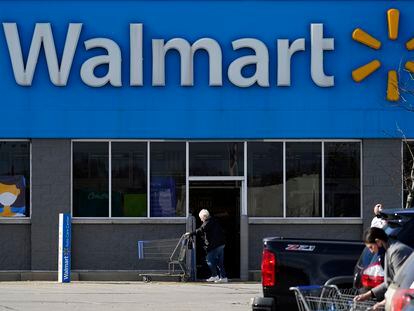 Una mujer pasa con un carro de la compra por delante de una tienda de Walmart en Illinois.