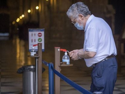 Un hombre usa un dispensador de gel hidroalcohólico en la catedral de Sevilla. 
