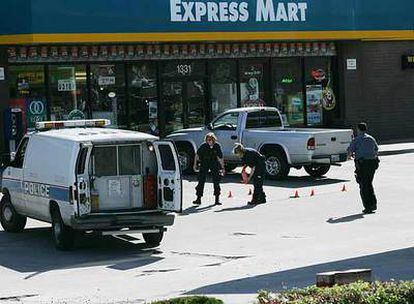 Varios policías inspeccionan el aparcamiento del centro comercial de Kansas City en el que un hombre ha matado a dos personas y ha dejado heridas a varias.