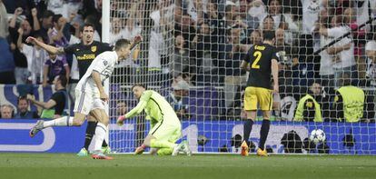 El delantero portugués del Real Madrid Cristiano Ronaldo (i) lanza a puerta para marcar su tercer gol ante el Atlético de Madrid.