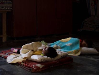 Dos niños duermen la siesta sobre unas mantas colocadas en el suelo de una vivienda del asentamiento temporal de Hauch er-Rafqa, en Líbano.
