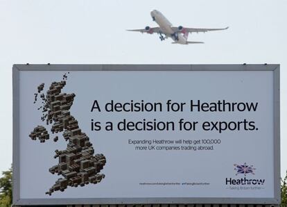 Un avión despega en el aeropuerto londinense de Heathrow. En primer término, un cartel publicitario en defensa de la ampliación.