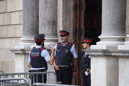 Tres agents de la policia catalana parlen a la porta del Palau de la Generalitat, a Barcelona, aquest dissabte.