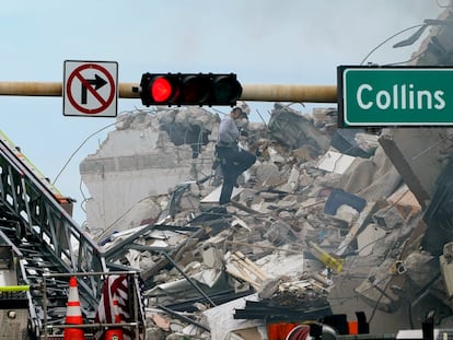 Un rescatista remueve escombros del edificio de apartamentos colapsado en Miami en busca de supervivientes.