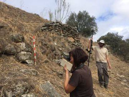 Dos arqueólogos, frente a los restos de la muralla de Tamusia, en Botija (Cáceres).