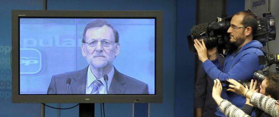 Mariano Rajoy comparece ante los periodistas a través de una pantalla de plasma.