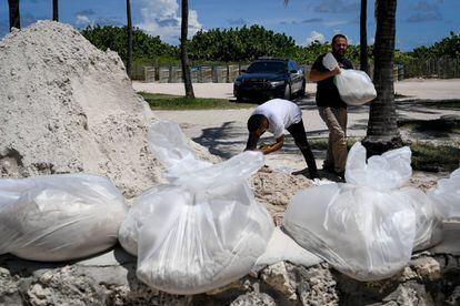 Dos residentes colocan grandes bolsas de arena como prevención ante la llegada del huracán Irma en Miami Beach, Florida (EE UU), el 8 de septiembre.
