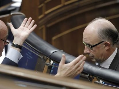 Luis de Guindos y Cristóbal Montoro, conversan durante el Pleno del Congreso.