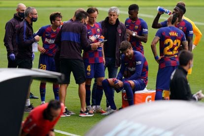 El entrenador Quique Setién da instrucciones a sus jugadores, entre ellos Gerard Piqué (sentado en una nevera), durante una de las pausas de hidratación en el Celta -Barcelona, en 2020.