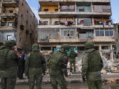 Soldados rusos frente a los escombros de los edificios derruidos en Alepo (Siria), el martes.