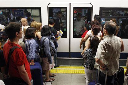 Un grupo de viajeros aguarda la apertura de puertas de un vagón en la estación de Nuevos Ministerios.