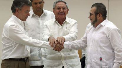 Juan Manuel Santos y Timochenko, líder de las FARC, se dan la mano en La Habana ante el líder cubano Raúl Castro, el pasado septiembre