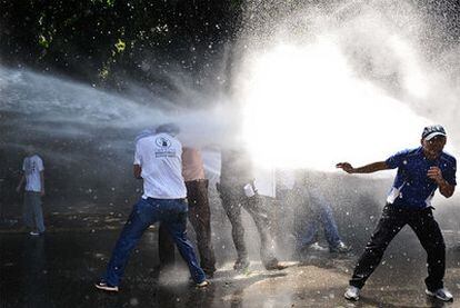 La policía venezolana intenta disolver con un cañón de agua a presión una manifestación de estudiantes contra la reforma de la legislación universitaria, el jueves en Caracas.