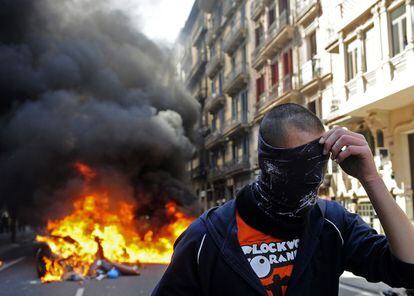 Un manifestante se cubre la cara durante la huelga general en Barcelona.