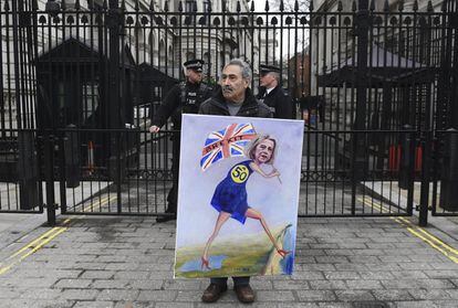 El artista satírico Kay Mar, en Downing Street, con una pintura que representa a la primera ministra británica, Theresa May, con la bandera de la Union Jack en defensa del artículo 50 del Tratado de Lisboa, en Londres.