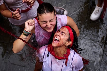 Jóvenes celebran el chupinazo por las calles de Pamplona, este jueves.