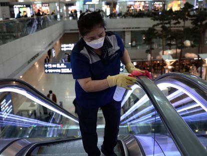 Trabajadores desinfectan unas escaleras mecánicas en el aeropuerto de Incheon (Corea del Sur). 