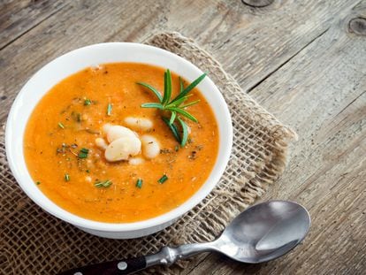 Creamy white bean and vegetable soup with rosemary on wooden background - healthy homemade diet vegetarian vegan soup meal food