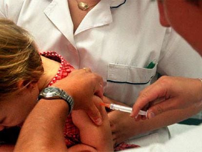Una enfermera vacuna a una niña en un centro de salud.