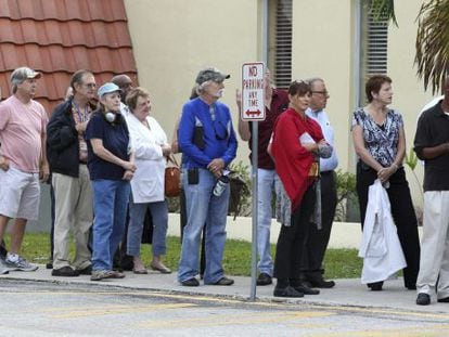 Varias personas esperan en fila para ejercer su derecho al voto en un colegio electoral en Miami.