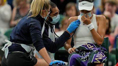Britain's Emma Raducanu receive medical attention during the women's singles fourth round match against Australia's Ajla Tomljanovic on day seven of the Wimbledon Tennis Championships in London, Monday, July 5, 2021. (AP Photo/Alastair Grant)